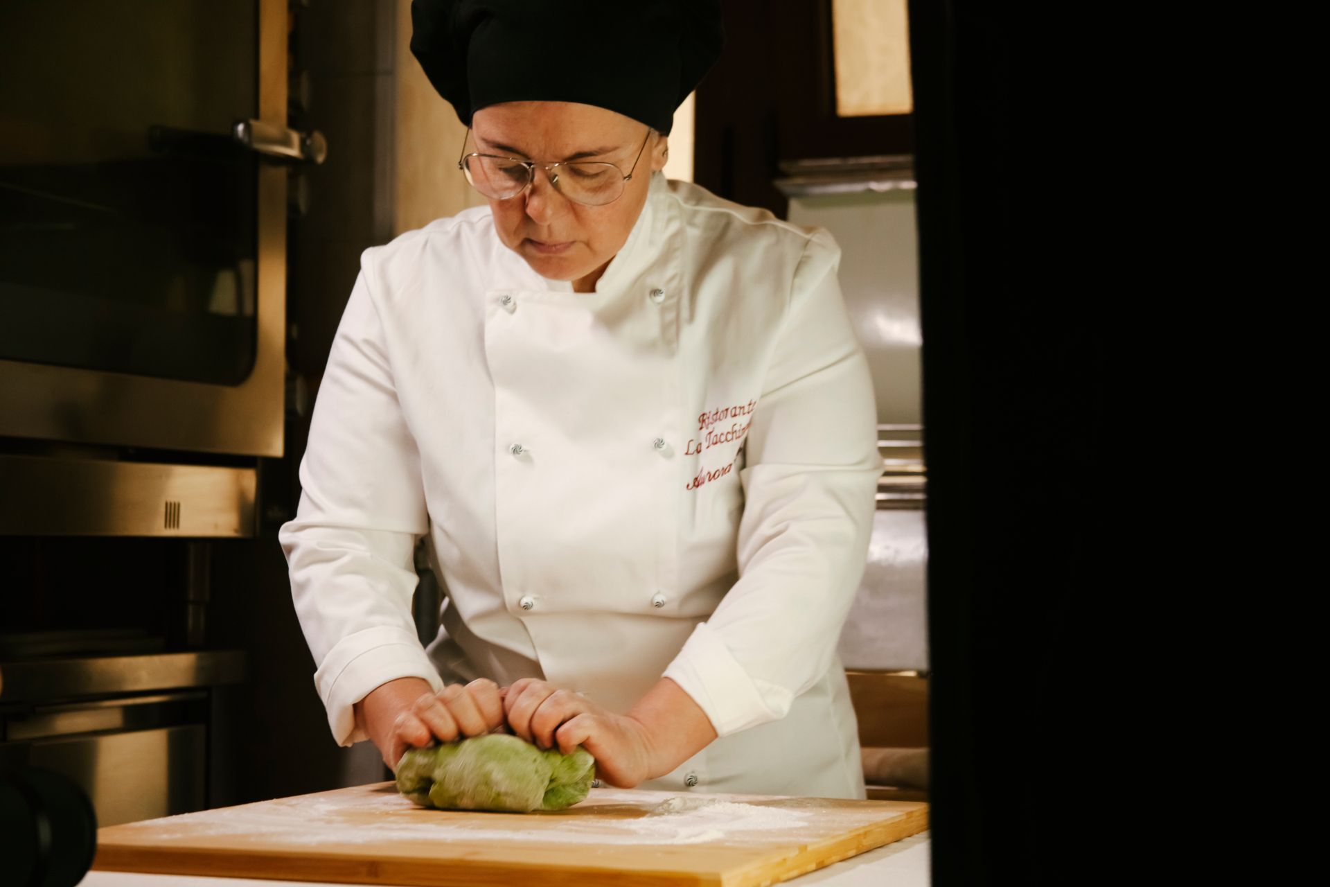 Aurora chef durante mentre ammassa piatto Tricolore fettuccine all'uovo di spinaci con funghi e tartufo del Ristorante La Tacchinella di Canzano a Teramo in Abruzzo