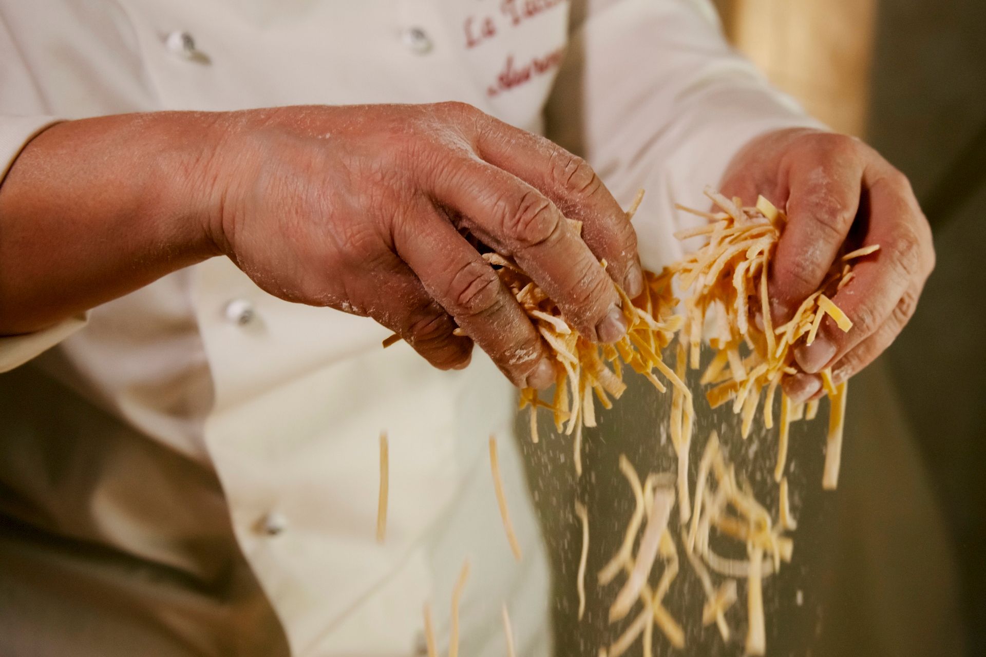 mani Aurora chef durante preparazione piatto Tricolore fettuccine all'uovo di spinaci con funghi e tartufo del Ristorante La Tacchinella di Canzano a Teramo in Abruzzo