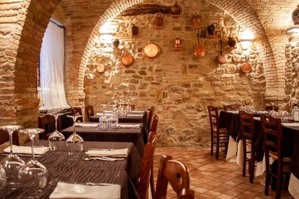 sala principale in pietra con tavoli apparecchiati del ristorante La Tacchinella cucina tipica teramana abruzzese a Canzano