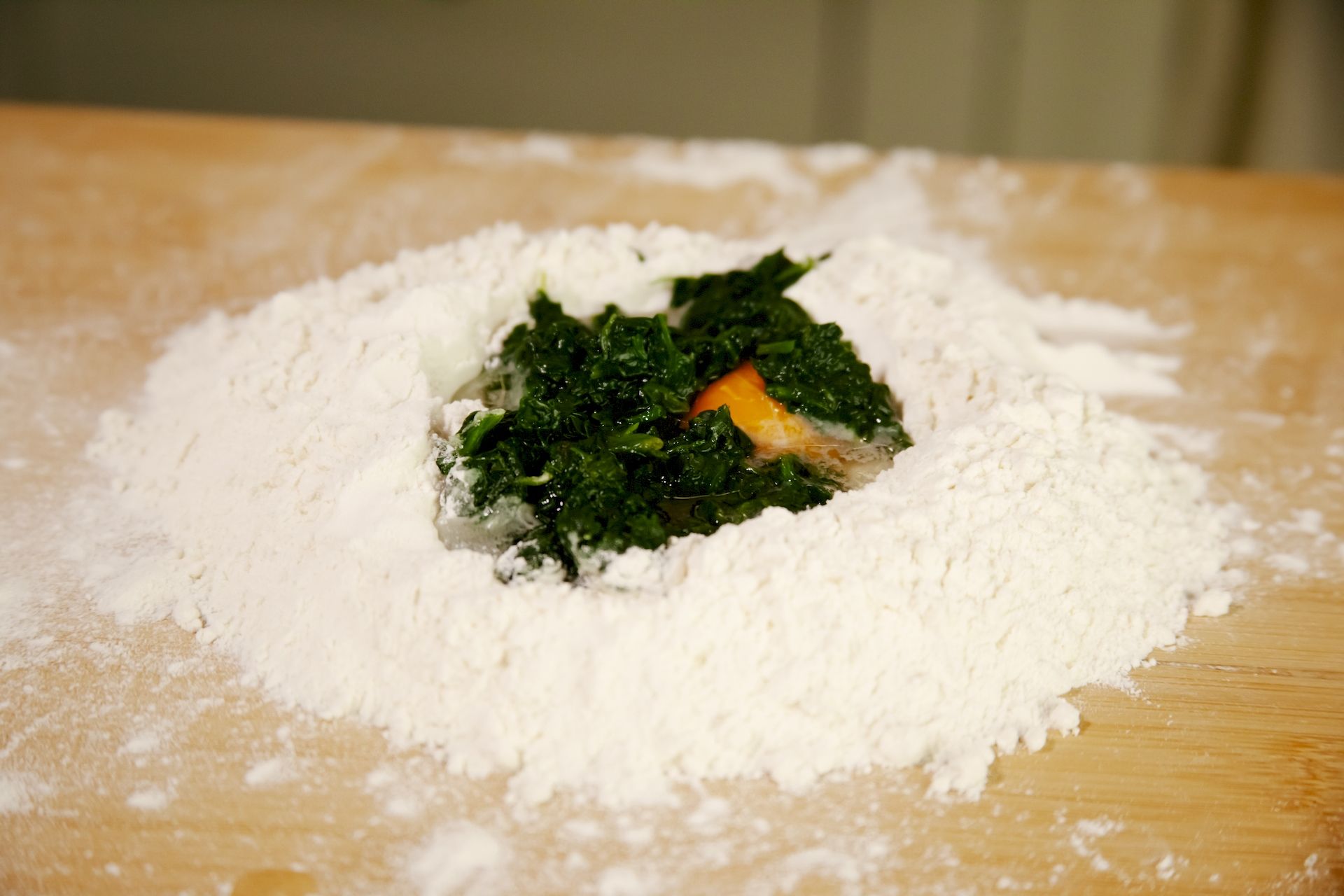 spinaci farina e uova su tavola di legno preparazione piatto Tricolore fettuccine all'uovo di spinaci con funghi e tartufo del Ristorante La Tacchinella di Canzano a Teramo in Abruzzo